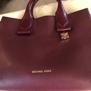 Burgundy Michael Kors hand bag with gold hardware